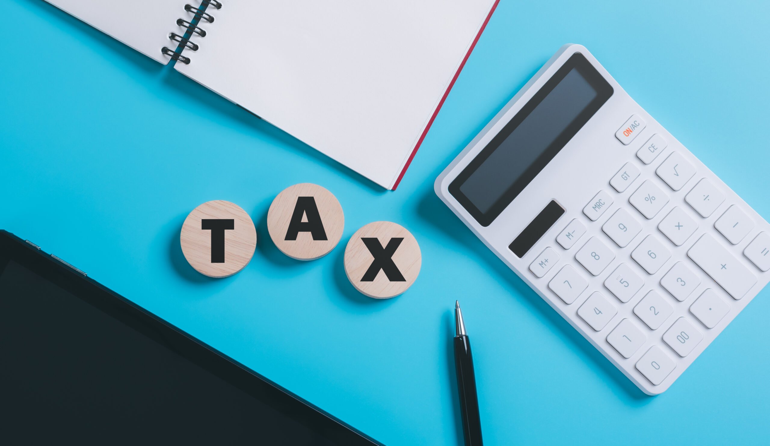 wooden block calculator placed on a blue background, tax rate calculation and the financial budget of the business effective tax deduction planning concepts for individuals and companies ,state taxes